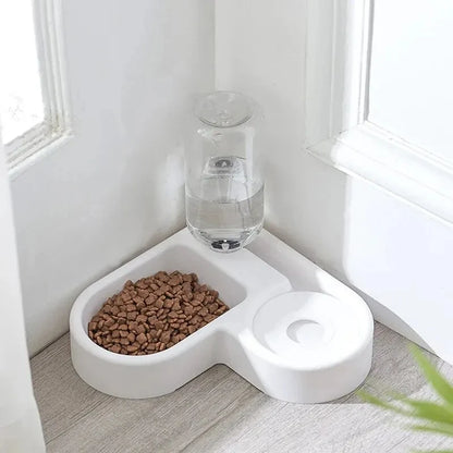 Pet food bowl with water dispenser on a light wood floor.